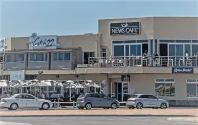 a building with cars parked in a parking lot at Blouberg,1106 Portico,Cape town in Cape Town