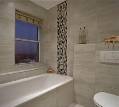 a bathroom with a tub and a toilet and a window at Blouberg,1106 Portico,Cape town in Cape Town