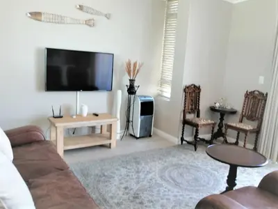 a living room with a couch and a flat screen tv at Blouberg,1106 Portico,Cape town in Cape Town