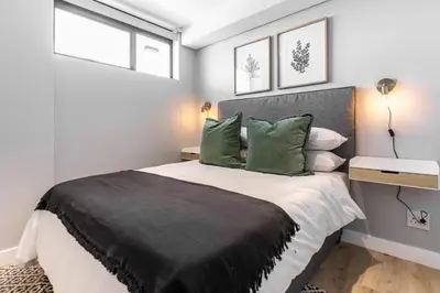 a bedroom with a large bed with green pillows at Burmeister403 - Modern 1 Bedroom Apartment across from Ocean in Cape Town