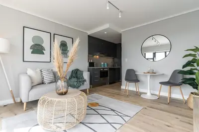 a living room with a couch and a table at Burmeister403 - Modern 1 Bedroom Apartment across from Ocean in Cape Town