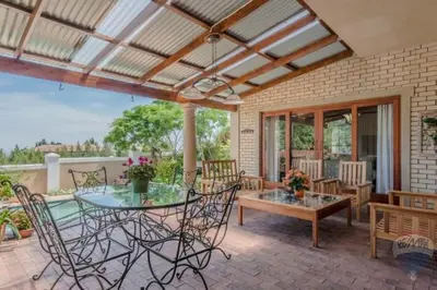 a patio with a table and chairs on a patio at Tuscany Hauss Villa in Somerset West