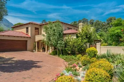 a large house with a garage and a driveway at Tuscany Hauss Villa in Somerset West