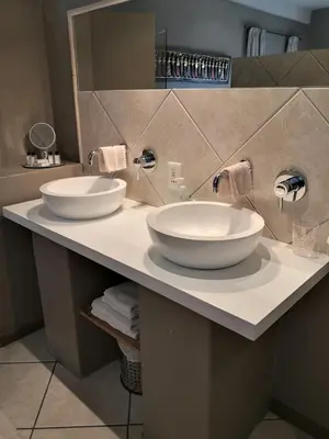 a bathroom with two white sinks on a counter at Perle Du Cap in Paarl