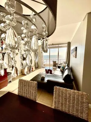 a living room with a couch and a chandelier at 502 Portico in Cape Town