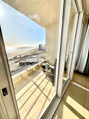 a room with a balcony with a view of the beach at 502 Portico in Cape Town