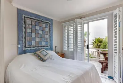 a bedroom with a bed and a balcony at 30 Nagua Bay in Cape Town