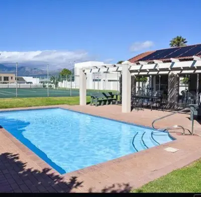 a large swimming pool in the middle of a yard at 30 Nagua Bay in Cape Town