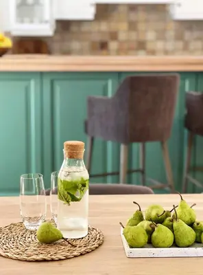 a bottle of vinegar and a plate of pears on a table at La Belle Vie in Franschhoek