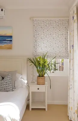 a bedroom with a bed and a window with a plant on a table at La Belle Vie in Franschhoek