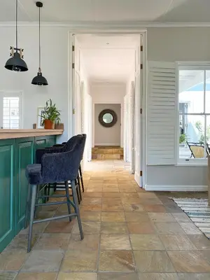a kitchen with green cabinets and a table and chairs at La Belle Vie in Franschhoek