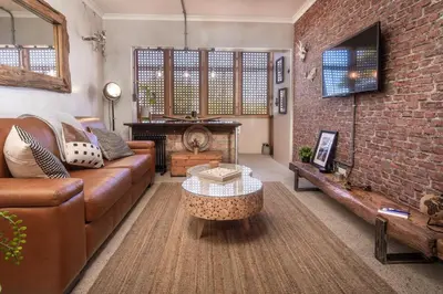 a living room with a couch and a piano at TnT on Main in Hermanus