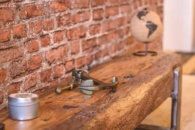 a wooden table with a wrench and a brick wall at TnT on Main in Hermanus