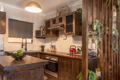 a kitchen with wooden cabinets and a counter top at TnT on Main in Hermanus