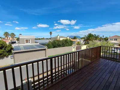 a deck with a view of the ocean and buildings at Lovely 2 bedroom condo with balcony and a view! in Cape Town
