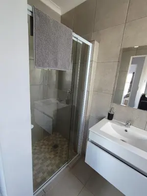 a bathroom with a shower and a sink and a tub at Lovely 2 bedroom condo with balcony and a view! in Cape Town