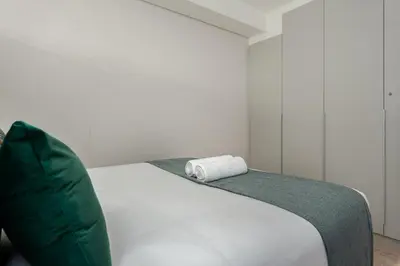 a white bed with a towel on top of it at Burmeister on Park Apartments in Cape Town