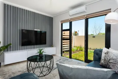 a living room with a tv and a couch and a table at Burmeister on Park Apartments in Cape Town