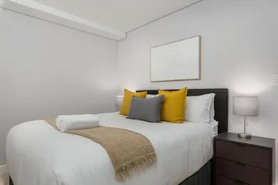 a bedroom with a large bed with yellow pillows at Burmeister on Park Apartments in Cape Town
