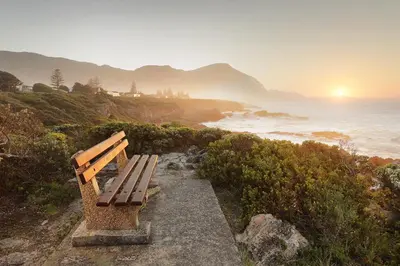 a bench sitting on a hill overlooking the ocean at Oak on Main in Hermanus