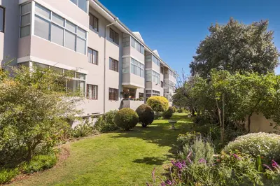 an apartment building with a garden in front of it at Oak on Main in Hermanus