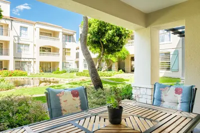 a patio with a table and chairs and a building at Belina - Bougain Villas Premier in Cape Town