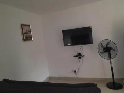 a living room with a fan and a flat screen tv at Oxford Getaway-House in Cape Town