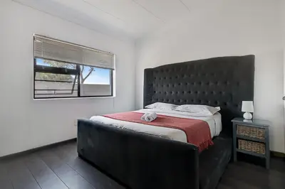 a bedroom with a large bed and a window at Spacious Shared 3-Bedroom Villa Near Blouberg Beach Pool, Wi-Fi, Braai in Cape Town