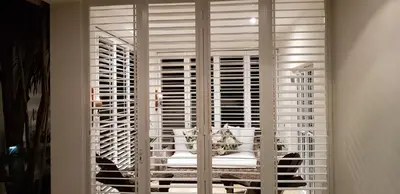 a room with white shutters on a window with a table at Stellenbosch Paradyskloof Unit in Stellenbosch