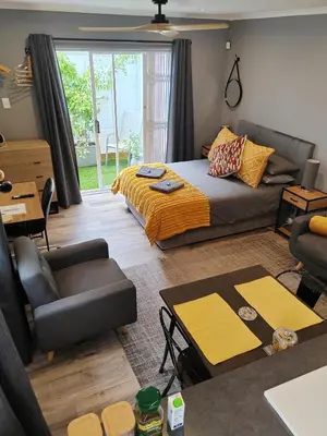a living room with a bed and a couch at Leafy Retreat Kenridge Trendy in Durbanville