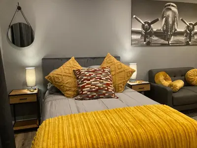a bedroom with a bed with a yellow blanket at Leafy Retreat Kenridge Trendy in Durbanville