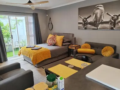 a living room with a bed and a couch at Leafy Retreat Kenridge Trendy in Durbanville