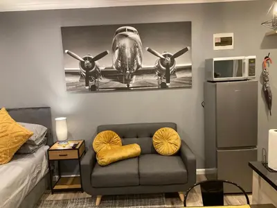 a room with a couch and an airplane on the wall at Leafy Retreat Kenridge Trendy in Durbanville