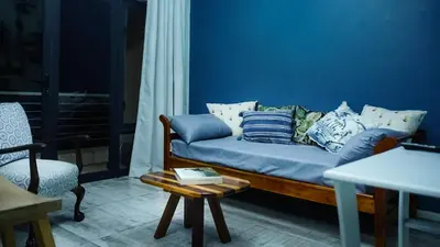 a blue living room with a couch and a table at 1-bedroom apartment with secure basement parking in Stellenbosch