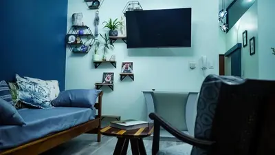 a living room with a couch and a tv at 1-bedroom apartment with secure basement parking in Stellenbosch