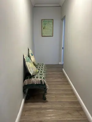 a hallway with a chair in a room at Botany House, in the heart of Hermanus in Hermanus