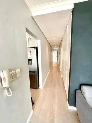 a hallway leading into a room with a refrigerator at 706 Portico in Cape Town