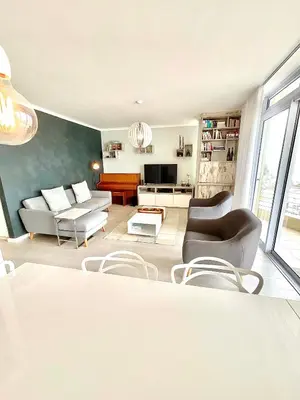 a living room with a couch and chairs and a tv at 706 Portico in Cape Town