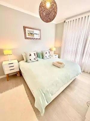 a bedroom with a large bed and a chandelier at 706 Portico in Cape Town