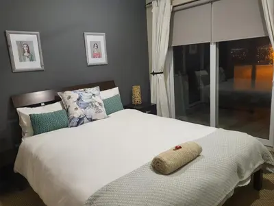 a bedroom with a bed with a pillow on it at Palm Zicht MAIN 3 bedroom apartment in Cape Town