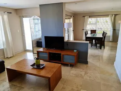 a living room with a tv and a coffee table at Palm Zicht MAIN 3 bedroom apartment in Cape Town
