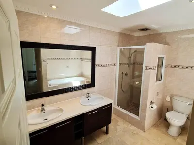 a bathroom with a sink and a toilet and a mirror at Palm Zicht MAIN 3 bedroom apartment in Cape Town