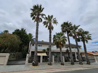 a group of palm trees in front of a building at Palm Zicht MAIN 3 bedroom apartment in Cape Town