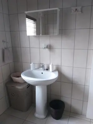 a white bathroom with a sink and a mirror at Prince Alfreds in Caledon