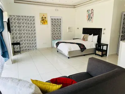 a bedroom with a bed and a couch at African Haven Guest House in Cape Town