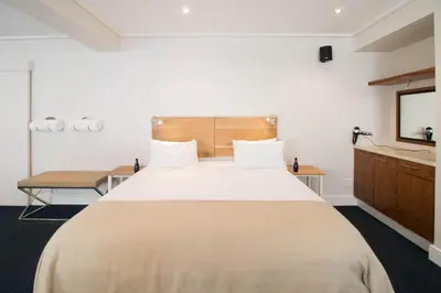 a bedroom with a large bed and a tv at Harbour House Hotel - Adventure Pads in Hermanus
