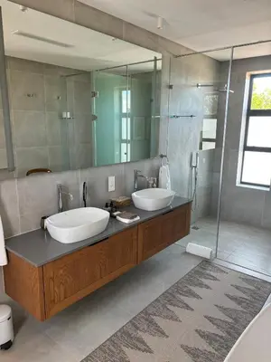 a bathroom with two sinks and a shower at Vergenoegd Löw Boutique Hotel & Spa in Somerset West