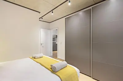 a bedroom with a bed with a yellow blanket at Bridgewater View 502 in Cape Town