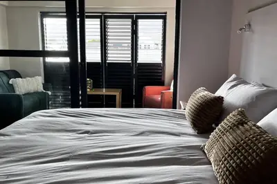 a white bed with two pillows on top of it at Hermanus Waterfront Apartment No.20 in Hermanus