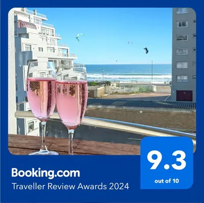 two glasses of pink champagne on a balcony with the beach at OCEAN VIEW, Blouberg Beach, Sunsets & Kite Beach in Bloubergstrand